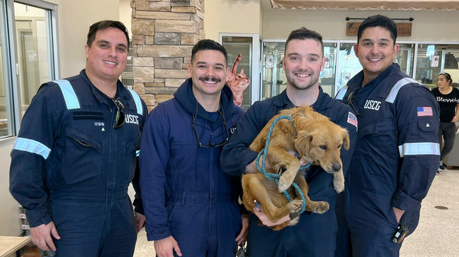 This image released by the U.S. Coast Guard, shows Connie the container dog, Wednesday, Jan. 31, 2024, with the four marine inspectors from the U.S. Coast Guard Sector Houston-Galveston who found her when randomly selecting containers for inspection at the Bayport Terminal at the Port of Houston. The officers heard sounds of barking and scratching coming from inside one of the stacked shipping containers. Coast Guard officials would later determine the canine had been trapped inside for at least eight days, with no food or water. (Petty Officer 1st Class Lucas Loe/U.S. Coast Guard via AP)