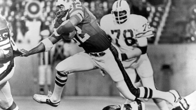 FILE - Buffalo Bills runningback O.J. Simpson (32) runs over some teammates as he latches onto Joe DeLamielleurs (68) during an NFL football game against the Tampa Bay Buccaneers at Rich Stadium in Buffalo, N.Y., Sept. 3, 1977. Buccaneers Council Rudolph (78) follows at right. (AP Photo/File)