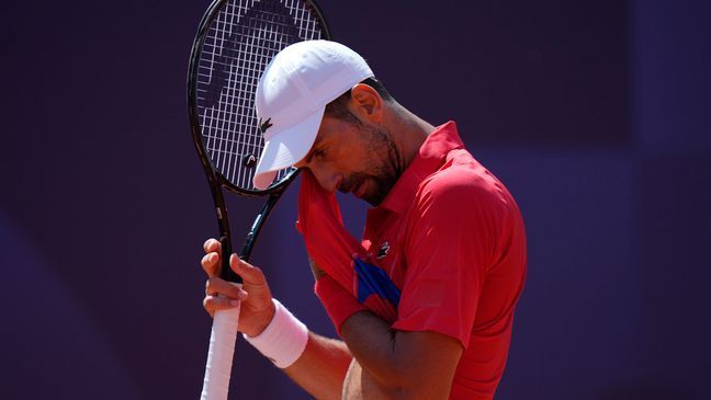 Serbia's Novak Djokovic wipes his face as he plays Spain's Rafael Nadal during their men's singles second round match at the 2024 Summer Olympics, Monday, July 29, 2024, at the Roland Garros stadium in Paris, France. (AP Photo/Andy Wong)