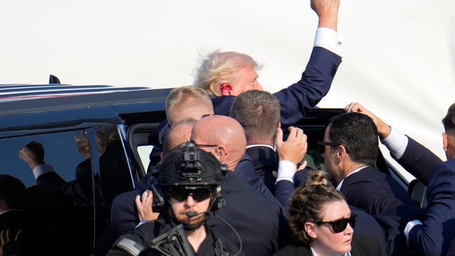 Republican presidential candidate former President Donald Trump pumps his fist as he is helped into a vehicle at a campaign event in Butler, Pa., on Saturday, July 13, 2024. (AP Photo/Gene J. Puskar)