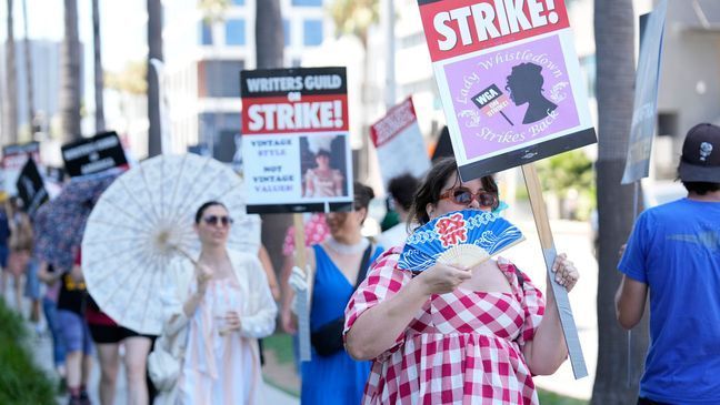 FILE - Picketers dressed as characters from "Bridgerton" carry signs outside Netflix studios on Tuesday, July 18, 2023, in Los Angeles.{&nbsp;} (AP Photo/Chris Pizzello)