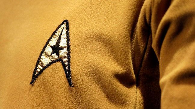 In this photo taken Wednesday, May 18, 2016, a Starfleet insignia appears on the original tunic worn by Capt. James T. Kirk, played by William Shatner, in the exhibit, "Star Trek: Exploring New Worlds," as part of a 50th anniversary celebration of the "Star Trek" franchise at the EMP Museum, in Seattle. (AP Photo/Elaine Thompson)