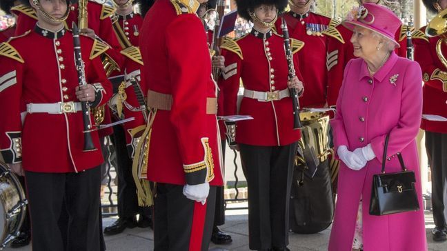 Britain's Queen Elizabeth II , right, talks to a member of the Royal Guard as she officially opens the new Bandstand at Alexandra Gardens, a day ahead of her 90th birthday, in Windsor, England, Wednesday, April 20, 2016. (Arthur Edwards/Pool Photo via AP)