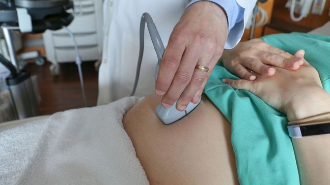 FILE - In this Aug. 7, 2018 file photo, a doctor performs an ultrasound scan on a pregnant woman at a hospital in Chicago. (AP Photo/Teresa Crawford)