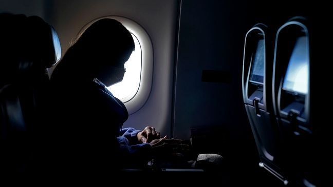 FILE - In this Wednesday, Feb. 3, 2021, file photo, a passenger wears a face mask she travels on a flight from Hartsfield-Jackson International Airport in Atlanta. (AP Photo/Charlie Riedel, File)