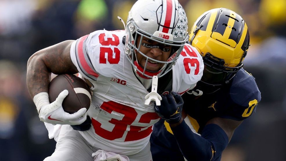 ANN ARBOR, MICHIGAN - NOVEMBER 25: TreVeyon Henderson #32 of the Ohio State Buckeyes runs with the ball against Mike Sainristil #0 of the Michigan Wolverines during the second quarter in the game at Michigan Stadium on November 25, 2023 in Ann Arbor, Michigan. (Photo by Ezra Shaw/Getty Images)