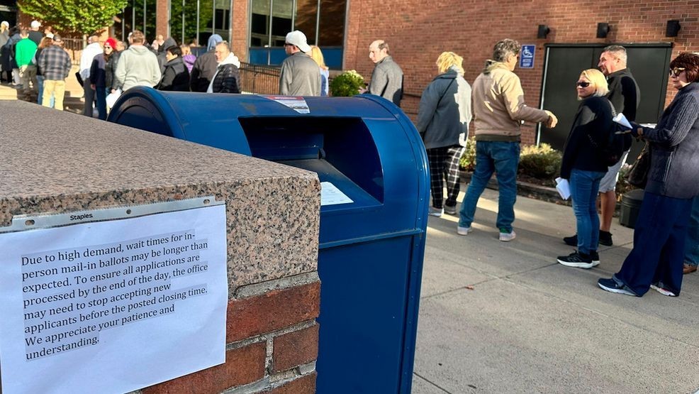 People wait in line outside the Bucks County government building to apply for an on-demand mail ballot on the last day to request one in Doylestown, Pa., Tuesday, Oct. 29, 2024. (AP Photo/Mike Catalini)