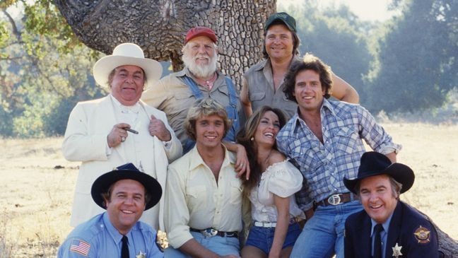 "The Dukes of Hazzard" cast members (Front row, from left) Rick Hurst (as Deputy Cletus Hogg); John Schneider (as Bo Duke); Catherine Bach (as Daisy Duke); Tom Wopat (as Luke Duke) and James Best (as Sheriff Rosco P. Coltraine). Basset hound Sandy (as Flash). Back row, from left: Sorrell Booke (as Jefferson Davis (J.D.) Hogg); Denver Pyle (as Uncle Jesse Duke) and Ben Jones (as Cooter Davenport). (Photo by CBS via Getty Images)