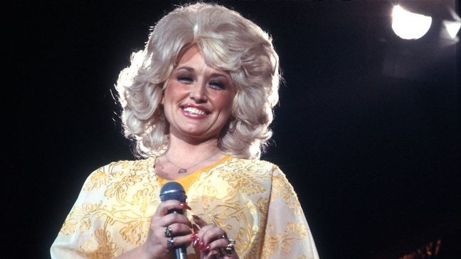 LOS ANGELES - CIRCA 1975: Country singer Dolly Parton performs onstage wearing a yellow dress, circa 1975, Los Angeles, California. (Photo by Michael Ochs Archives/Getty Images)