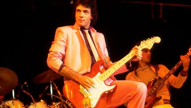 American Rock musician Rick Springfield plays guitar as he performs onstage at the Mill Run Theater, Niles, Illinois, September 6, 1981. (Photo by Paul Natkin/Getty Images)