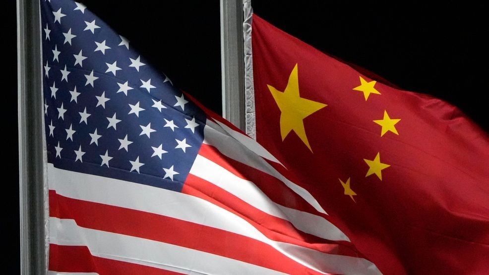 FILE - The American and Chinese flags wave at Genting Snow Park ahead of the 2022 Winter Olympics, Feb. 2, 2022, in Zhangjiakou, China. (AP Photo/Kiichiro Sato, File)