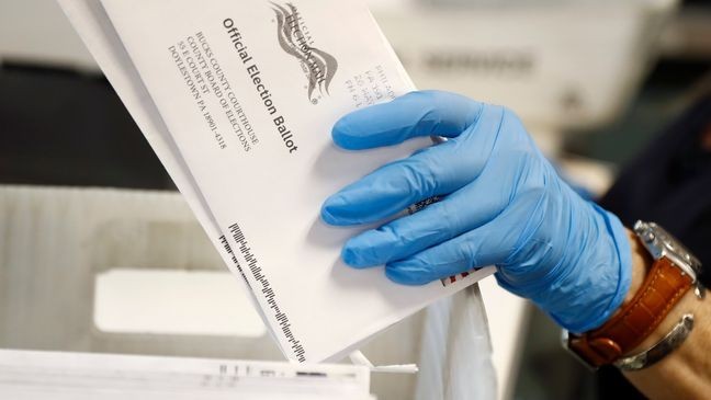 FILE - A worker processes mail-in ballots at the Bucks County Board of Elections office prior to the primary election in Doylestown, Pa., May 27, 2020. (AP Photo/Matt Slocum, File)