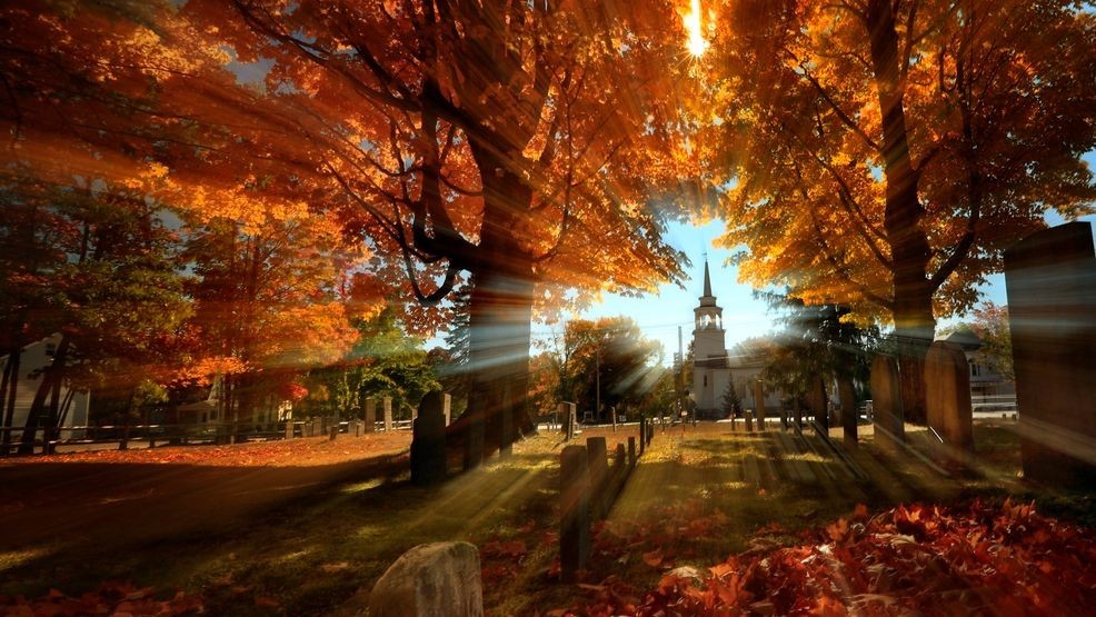 FILE - In this photo taken with a slow shutter speed, autumn's colors peak on hardwood trees in a cemetery near the Congregational Church, Monday, Oct. 10, 2016, in Cumberland, Maine. (AP Photo/Robert F. Bukaty, File)