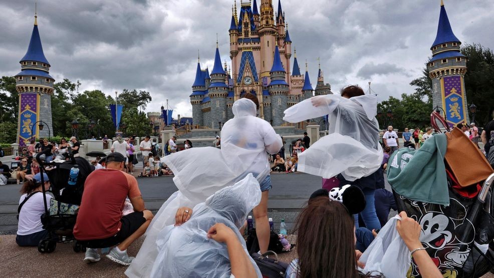 Guests at the Magic Kingdom break out ponchos at Cinderella Castle as bands of weather from Hurricane Helene move through Walt Disney World in Bay Lake, Fla., Thursday, Sept. 26, 2024. (Joe Burbank/Orlando Sentinel via AP)