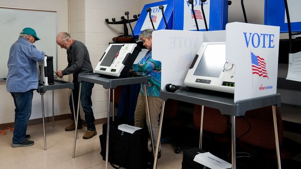 Poll workers set up ballot-marking machines at an early in-person voting site at Asheville-Buncombe Technical Community College, Wednesday, Oct. 16, 2024, in Marshall, N.C. (AP Photo/Stephanie Scarbrough)