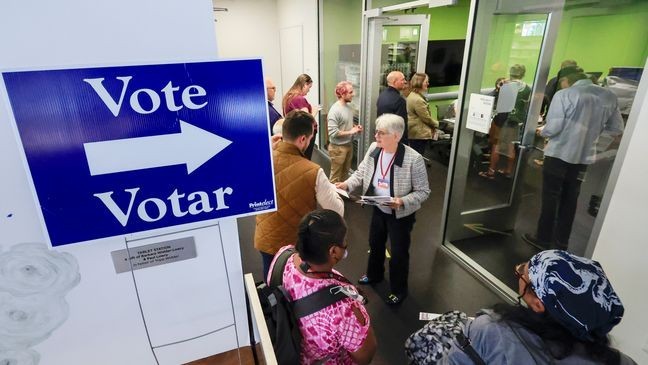 People lineup to vote on the first day of Wisconsin's in-person absentee voting at the Madison Public Library in Madison, Wisc., Tuesday, Oct. 22, 2024. (AP Photo/John Hart, Wisconsin State Journal)