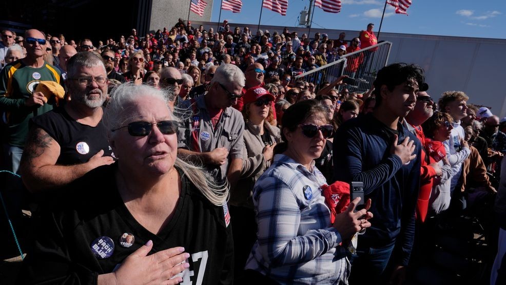 Attendees say the Pledge of Allegiance at a campaign rally for Republican presidential nominee former President Donald Trump at Dodge County Airport, Sunday, Oct. 6, 2024, in Juneau, Wis. (AP Photo/Julia Demaree Nikhinson)