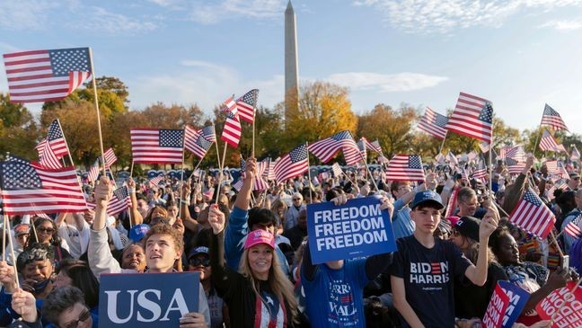 With the Washington Monument in the back ground supporters of Democratic presidential nominee Vice President Kamala Harris wave they American flags as they attend a campaign rally in Washington, Tuesday, Oct. 29, 2024. (AP Photo/Jose Luis Magana)