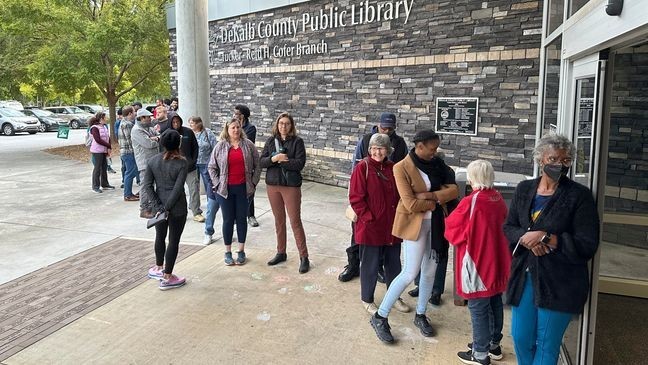 People line up to vote in the Atlanta suburb of Tucker, Ga., on Tuesday, Oct. 15, 2024, the first day of early in-person voting in Georgia. (AP Photo/Jeff Amy)