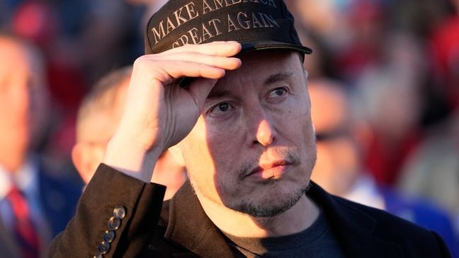 Tesla and SpaceX CEO Elon Musk listens as Republican presidential nominee former President Donald Trump speaks at a campaign event at the Butler Farm Show, Saturday, Oct. 5, 2024, in Butler, Pa. (AP Photo/Alex Brandon)