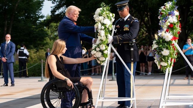 Former U.S. Marine Corps Cpl. Kelsee Lainhart left, and Republican presidential nominee former President Donald Trump place a wreath at the Tomb of the Unknown Solider in honor of the 13 service members killed at Abbey Gate, at Arlington National Cemetery, Monday, Aug. 26, 2024, in Arlington, Va. (AP Photo/Alex Brandon)