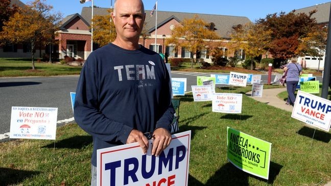 Jon Michael, a Republican who voted early for Republican former Gov. Larry Hogan for U.S. Senate in Maryland, as well as for former President Donald Trump, stands outside an early voting center on Kent Island in Chester, Md., Thursday, Oct. 24, 2024. (AP Photo/Brian Witte)