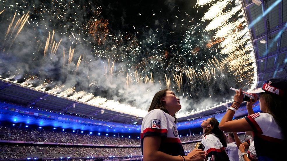 Athletes from the United States watch as fireworks explode during the 2024 Summer Olympics closing ceremony at the Stade de France, Monday, Aug. 12, 2024, in Saint-Denis, France. (AP Photo/Ashley Landis)