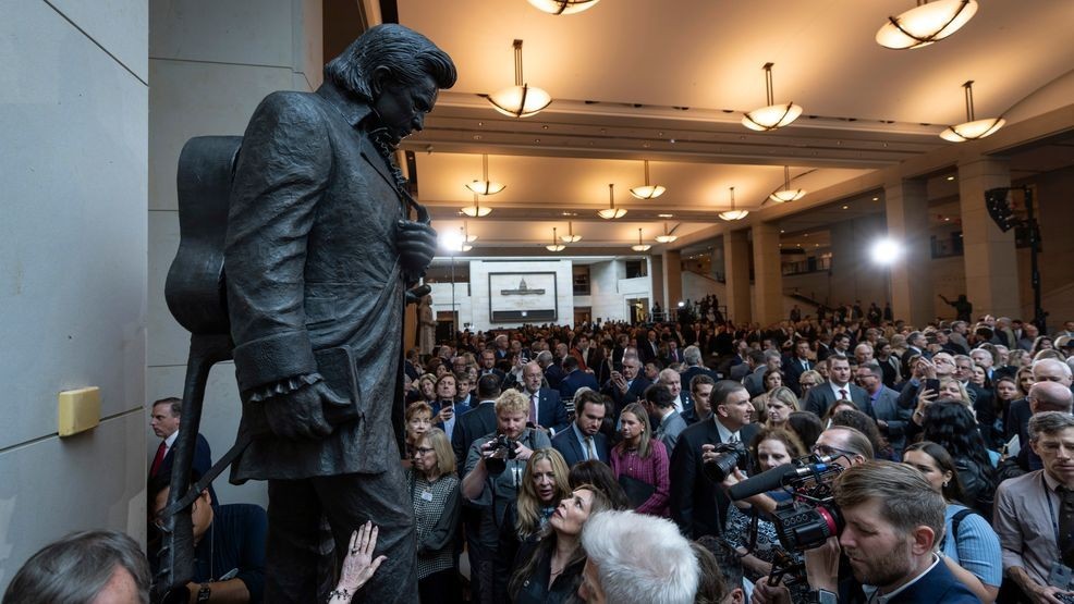 People crowd around after the unveiling of a bronze statue of singer Johnny Cash, created by Little Rock sculptor Kevin Kresse, in Emancipation Hall at the Capitol in Washington, Tuesday, Sept. 24, 2024. (AP Photo/Ben Curtis)