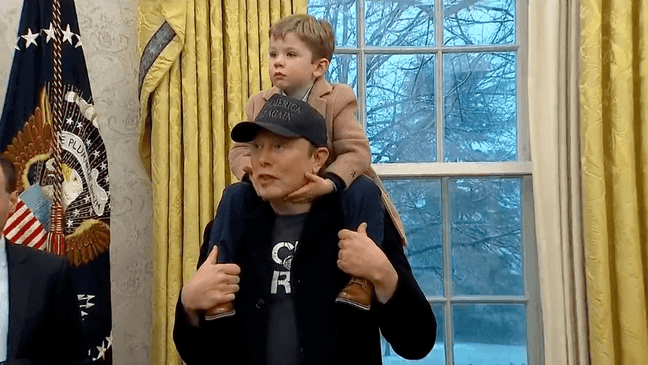 X on Elon Musk's shoulders in the Oval Office at the White House, Tuesday, Feb. 11, 2025, in Washington. (Pool)
