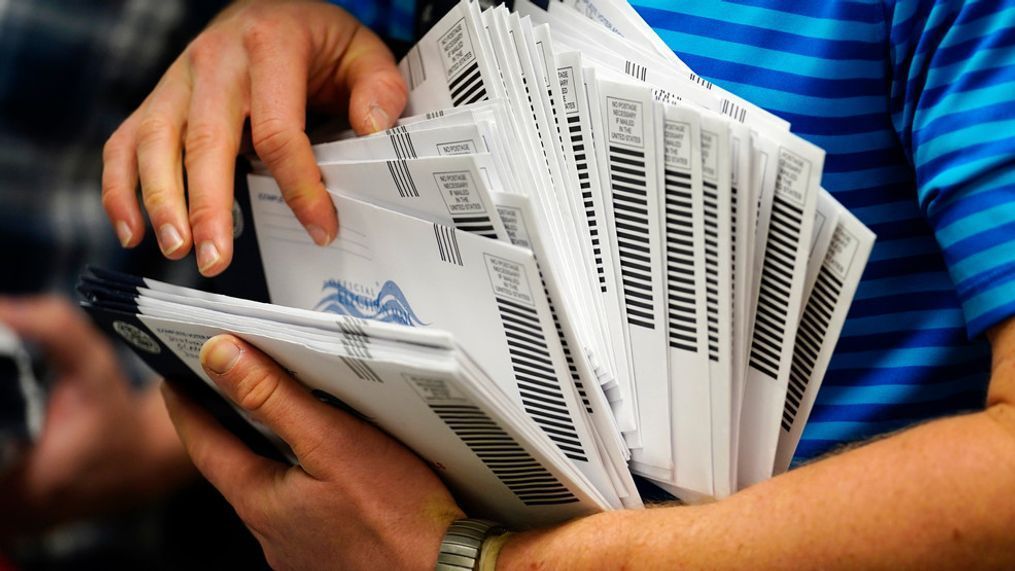 FILE - Kyle Hallman, with Chester County Voter Services, organizes mail-in ballots to be sorted for the 2020 General Election Oct. 23, 2020, in West Chester, Pa. (AP Photo/Matt Slocum, File)