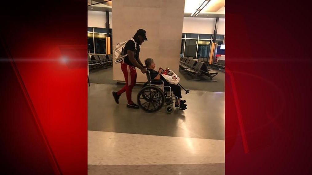 Packers running back, Aaron Jones, pushes a woman in a wheelchair at Appleton International Airport, May 28, 2018. (Photo courtesy of Monica Allen){p}{/p}