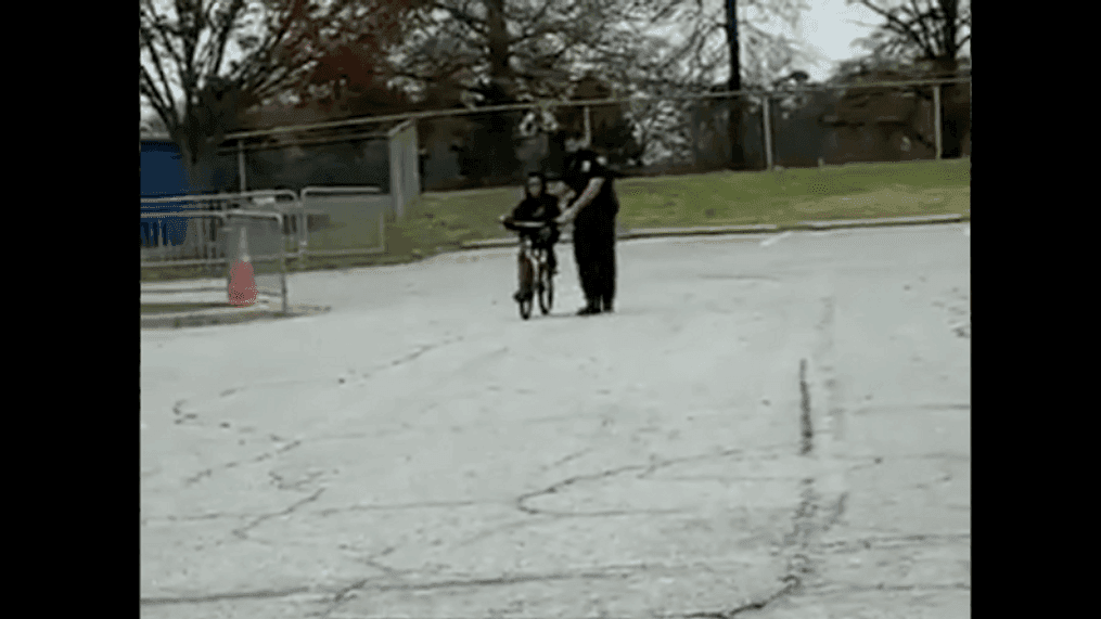 A police officer helps a child learn to ride a bicycle at the High Point Police Department in North Carolina. (Courtesy: High Point Police Department)