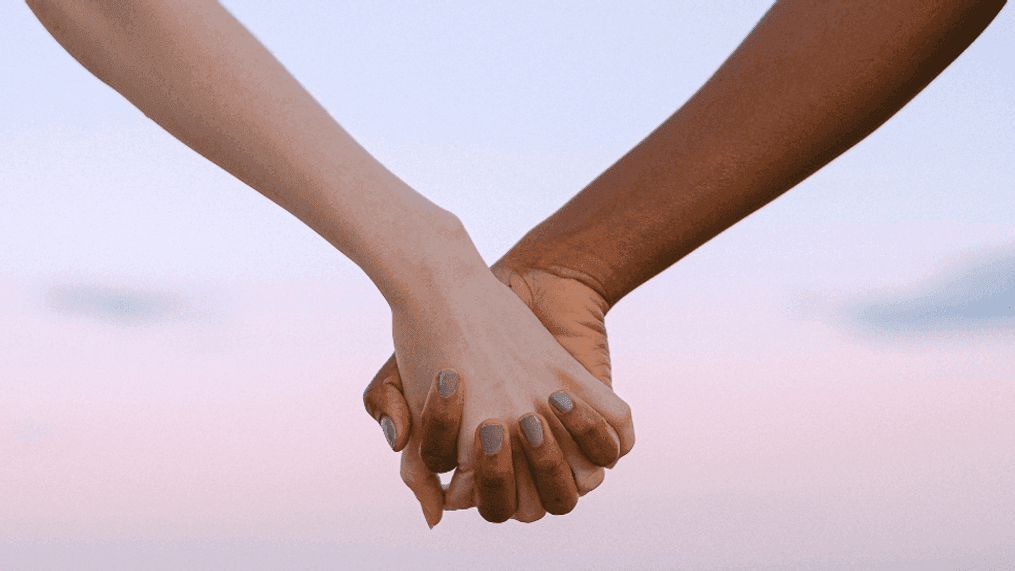 FILE - Two people hold hands (Canva/WWMT)