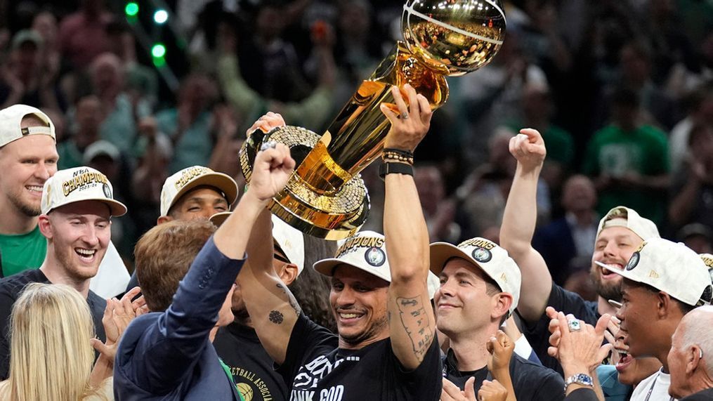 Boston Celtics head coach Joe Mazzulla, center, celebrates with the team as he holds up the Larry O'Brien Championship Trophy after they won the NBA basketball championship with a Game 5 victory over the Dallas Mavericks, Monday, June 17, 2024, in Boston. (AP Photo/Charles Krupa)