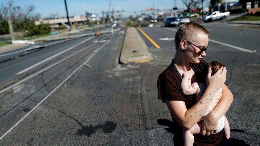 Kylie Strampe holds her four-month-old daughter, Lola, while surveying the damage from Hurricane Michael after riding out the storm in Callaway, Fla., Thursday, Oct. 11, 2018. (AP Photo/David Goldman)