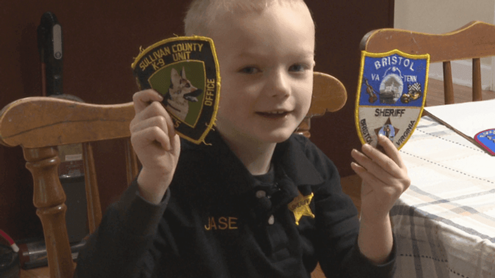 Police and fire patch collector Jase Groseclose with two of his favorite police patches (WCYB Photo)