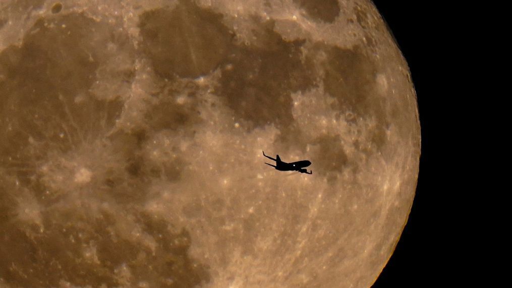 FILE - A plane passes in front of a full moon Wednesday, July 13, 2022, in Milwaukee. The moon's orbit brought it closer to Earth than usual. (AP Photo/Morry Gash)