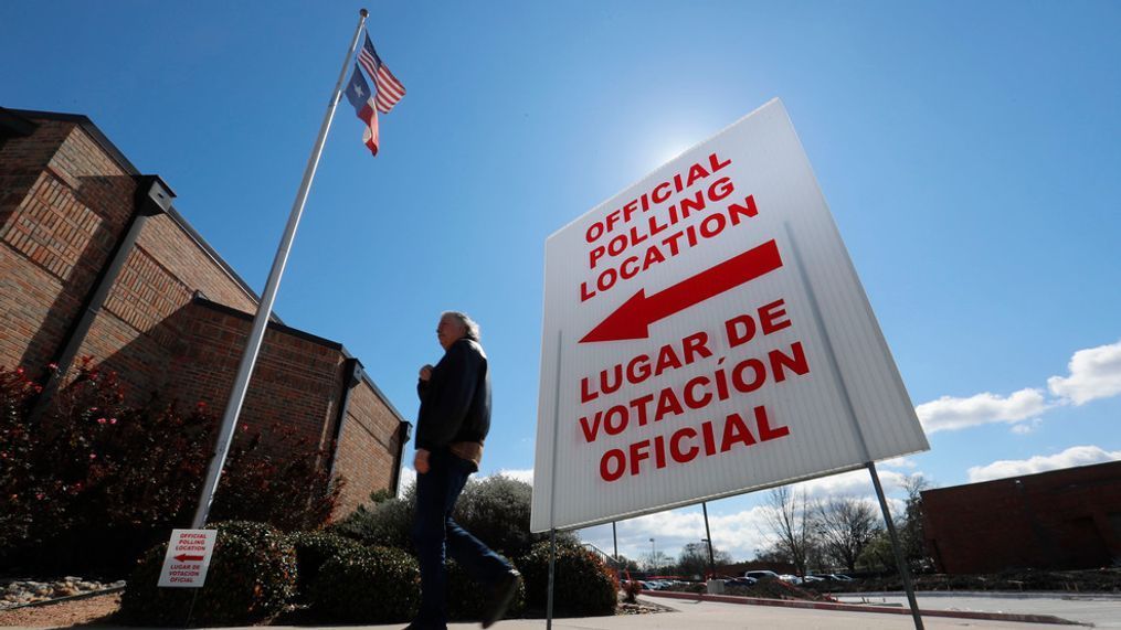 FILE - In this Feb. 26, 2020 file photo, using both the English and Spanish language, a sign points potential voters to an official polling location during early voting in Dallas. (AP Photo/LM Otero, File)