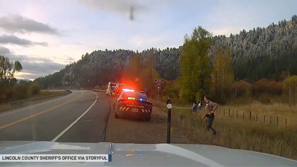 Dashcam footage shared by the sheriff’s office on October 11 shows a car skidding on black ice and spinning towards the deputy, who’s standing alongside his patrol car. (Lincoln County Sheriff's Office via Storyful)