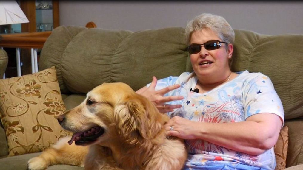 Mary Sedgwick was diagnosed with bilateral optic neuritis during her fourth year of medical school. Since 2003, she has been legally blind. But thanks to eSight Glasses, she was able to see her guide dog Lucy for the first time. (Photo credit: WLOS Staff)