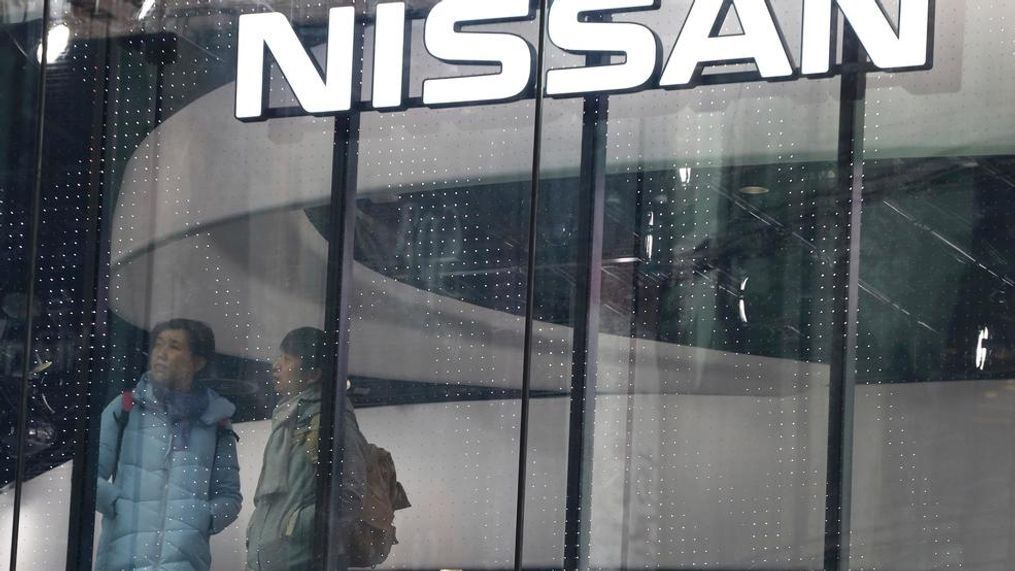 In this Feb. 5, 2019, photo, visitors stand near the logo of Nissan Nissan Motor Co. at its showroom in Tokyo. Nissan reported on Tuesday, Feb. 12, 20109, a drop in third quarter profit to about a fourth of the previous year’s because of the absence of perks from U.S. tax reforms that lifted profits a year ago. (AP Photo/Koji Sasahara)