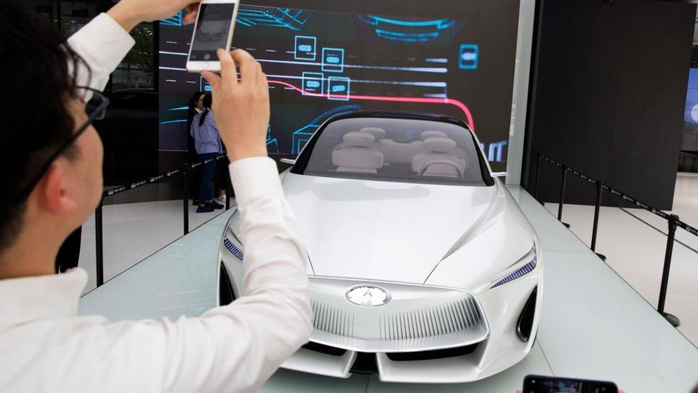 In this April 19, 2018, photo, visitors look at the Infiniti electric concept sedan at a showroom ahead of the Auto China 2018 to be held in Beijing, China. Auto China 2018, the biggest global auto show of the year, showcases China's ambitions to become a leader in electric cars and the industry's multibillion-dollar scramble to roll out models that appeal to price-conscious but demanding Chinese drivers. (AP Photo/Ng Han Guan)