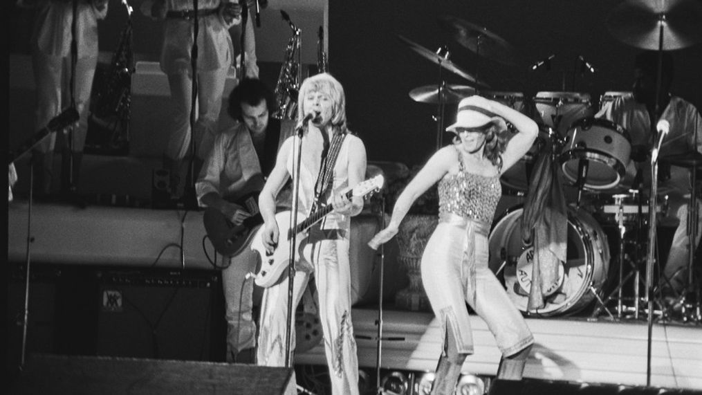 Swedish songwriter and musician Björn Ulvaeus and Norwegian-Swedish singer, songwriter, and environmentalist Anni-Frid Lyngstad of pop group ABBA performs on stage at the Royal Albert Hall, London, UK, 15th February 1977. (Photo by Frank Tewkesbury/Evening Standard/Hulton Archive/Getty Images)