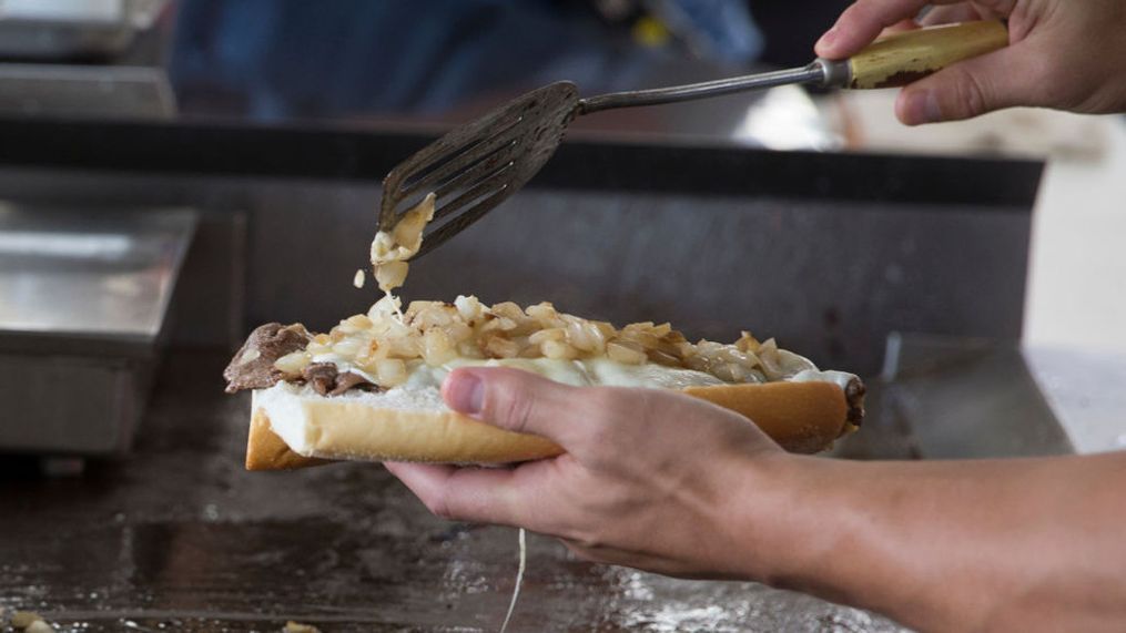 PHILADELPHIA, PA - SEPTEMBER 14: Juan Pablo Socino of the Newcastle Falcons makes a cheesesteak at Geno's Steaks on September 14, 2017 in Philadelphia, Pennsylvania. (Photo by Mitchell Leff/Getty Images)