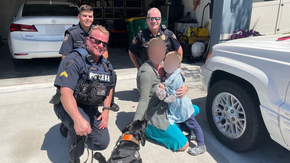K-9 Midnight, other DeLand police officers pose for a photo with the boy and his mother after they were reunited on Friday, March 29, 2024. (DeLand Police Department)
