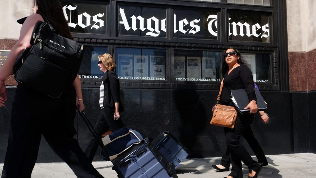 FILE - In this Oct. 5, 2015, file photo, pedestrians walk past the Los Angeles Times building in downtown Los Angeles. Newspaper publisher Gannett said Monday, April 25, 2016, that it wants to buy rival Tribune Publishing in a deal that would give the owner of USA Today control of the Los Angeles Times, the Chicago Tribune and several other newspapers. (AP Photo/Richard Vogel, File)