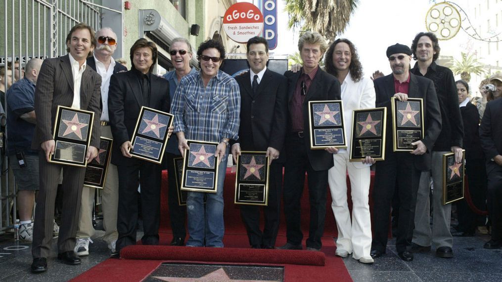 FILE - In this Jan. 21, 2005, file photo, members of the band Journey pose after receiving a star on the Hollywood Walk of Fame in Los Angeles. George Tickner is second from left, with the sunglasses and moustache (AP Photo/Nick Ut, File)