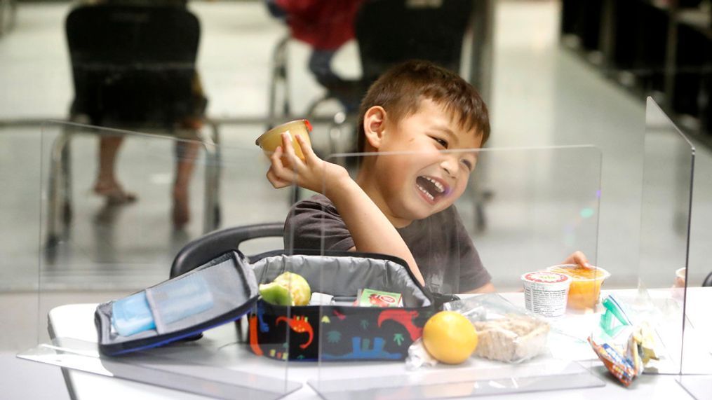 Bruce McCall, 5, laughs as he eats his lunch behind plastic barriers during martial arts daycare summer camp at Legendary Blackbelt Academy in Richardson, Texas, Tuesday, May 19, 2020. As daycare and youth camps re-open in Texas, operators are following appropriate safety measure to insure kids stay safe from COVID-19. (AP Photo/LM Otero)