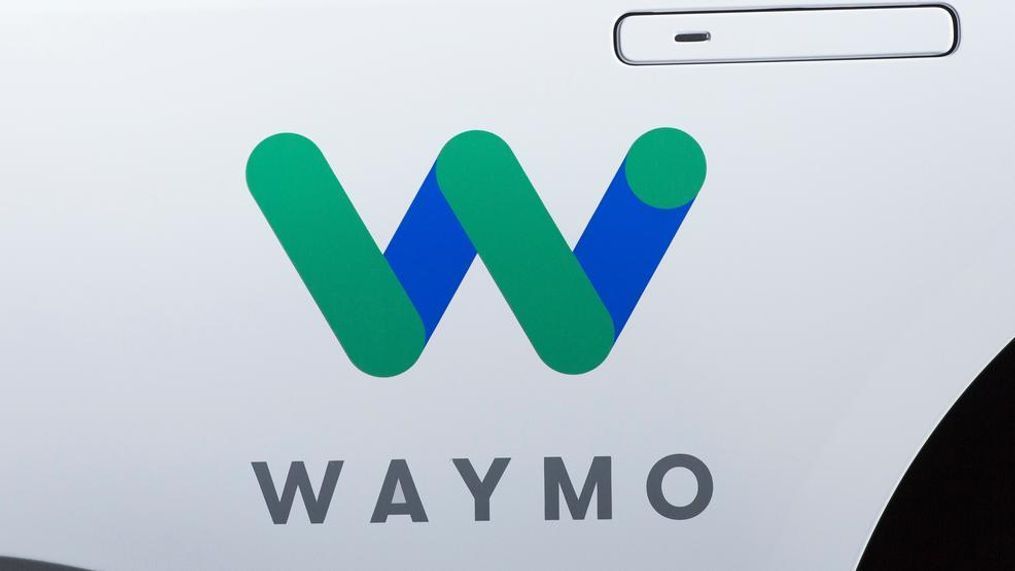 This March 27, 2018, file photo shows the Waymo logo on the of a Jaguar I-Pace vehicle, in New York. Google spinoff Waymo and Phoenix's major transit agency are partnering to test self-driving vehicles that would also boost public transportation use. Waymo announced in a blog post the start of a pilot program Tuesday, July 31, that would allow riders to hail an autonomous car to the nearest Valley Metro transit stop. (AP Photo/Mark Lennihan, File)