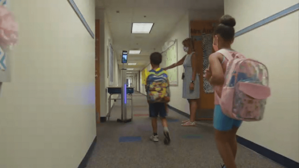 A teacher guides students into the classroom. (Photo: file){p}{/p}